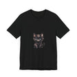 A fluffy white and grey kitten with bright blue eyes wears a playful and adorable t-shirt featuring a whimsical design