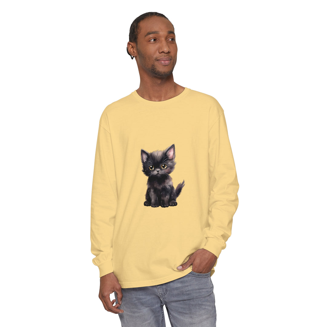 A cute black kitten with striking yellow eyes lounges on the front of a long sleeve t-shirt