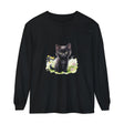 Black kitten sitting in a colorful flower garden, wearing a long sleeve T-shirt with a cute design