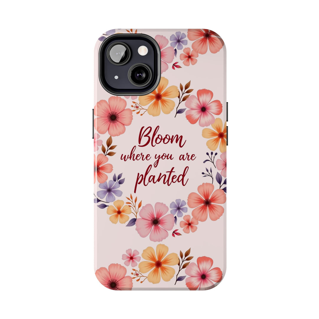 Light pink phone case with flower garland design that says 'Bloom where you are planted' on it