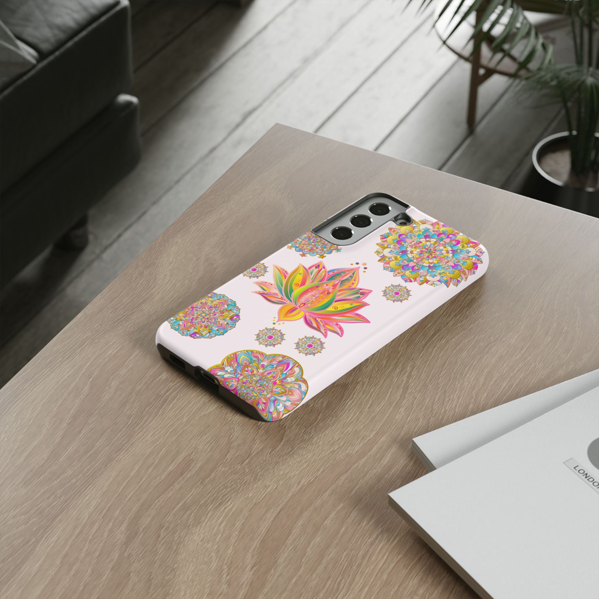 A light pink phone case with a mandala design and lotus flower pattern