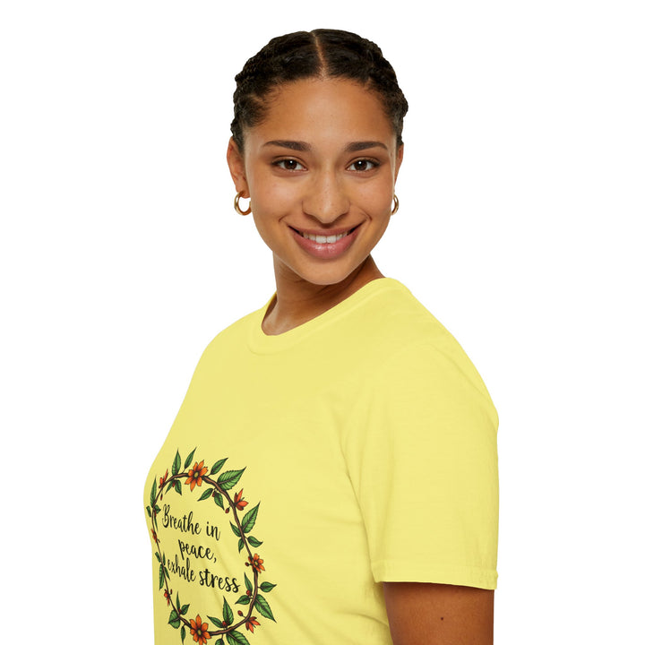 A close-up image of a soft, comfortable T-shirt featuring a floral garland design and the phrase Breathe in Peace Exhale Stress in elegant, cursive font