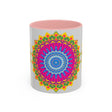 A colorful ceramic mug with a geometric mandala art design in vibrant shades of blue, red, and yellow