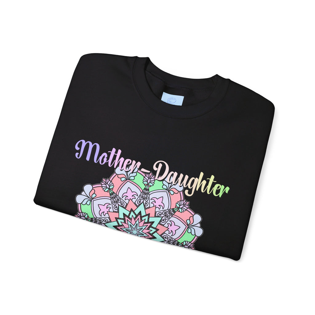 Mother and daughter embracing in a warm hug, wearing matching 'Mother-Daughter Bond' Unisex Heavy Blend™ Crewneck Sweatshirts, the perfect birthday gift for Mom