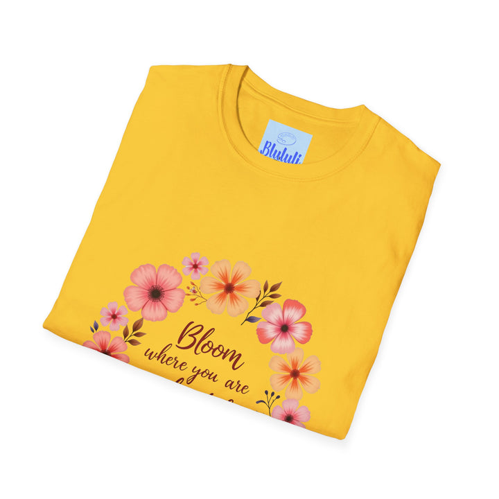 A close-up image of a black t-shirt with a colorful floral mandala design and the quote Be Kind in elegant script font