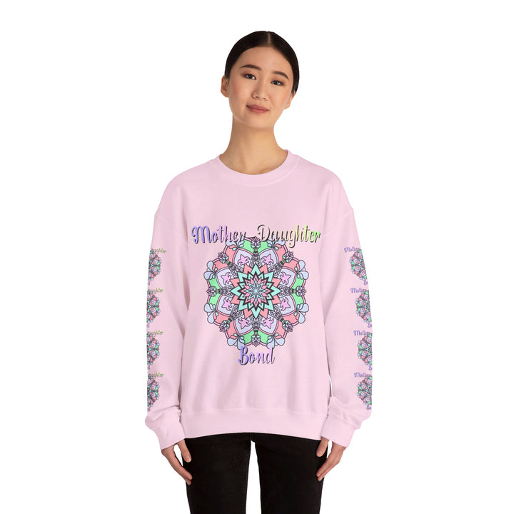 Mother and daughter holding hands while wearing matching 'Mother-Daughter Bond' Unisex Heavy Blend™ Crewneck Sweatshirts, the perfect birthday gift for mom