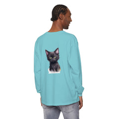 Cute black kitten with striking green eyes relaxing on a soft, comfortable t-shirt