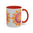 A close-up photo of a white ceramic mug with a colorful mandala-style floral design on it