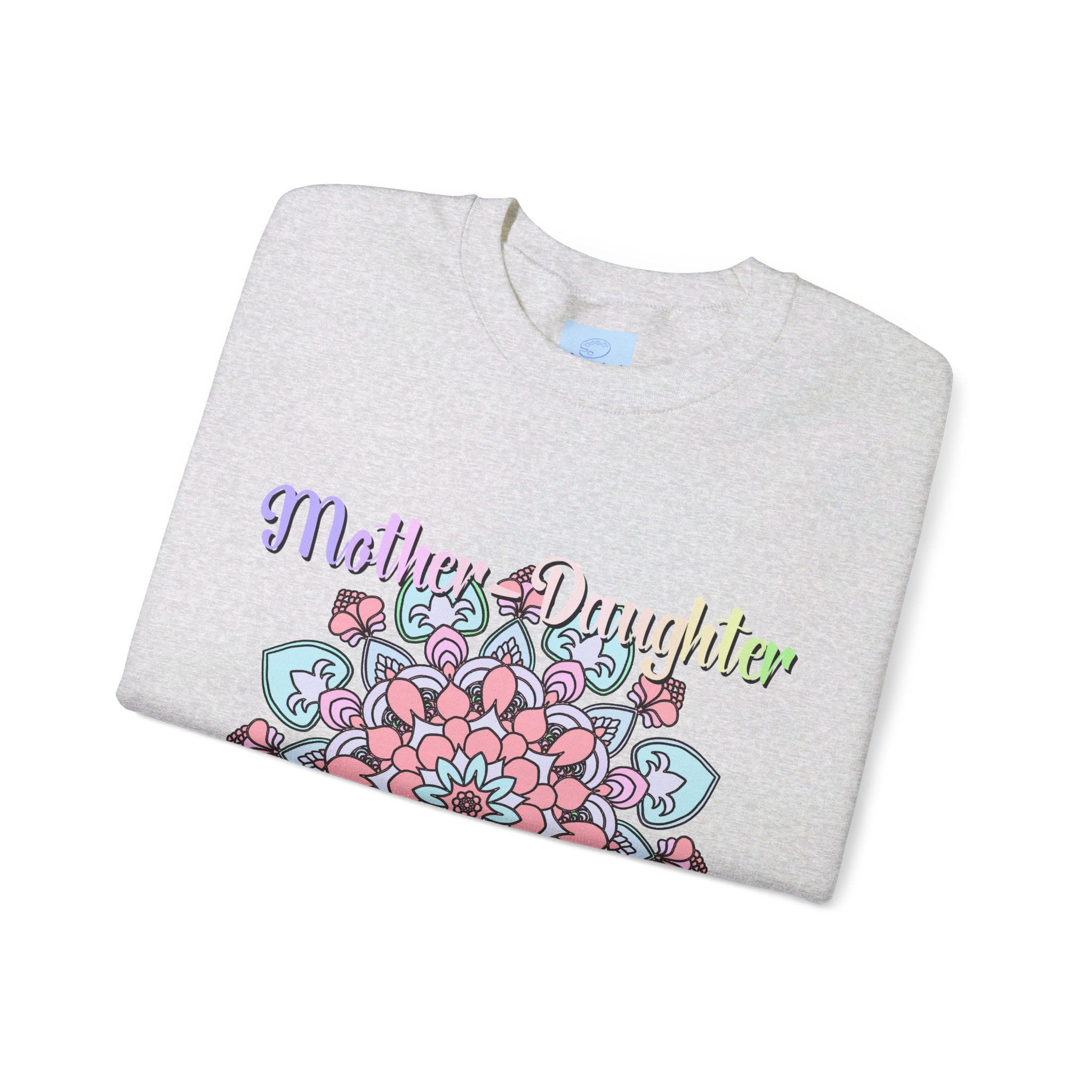 Mother and daughter holding hands, wearing matching Mother-Daughter Bond Unisex Heavy Blend™ Crewneck Sweatshirts, the perfect birthday gift for Mom