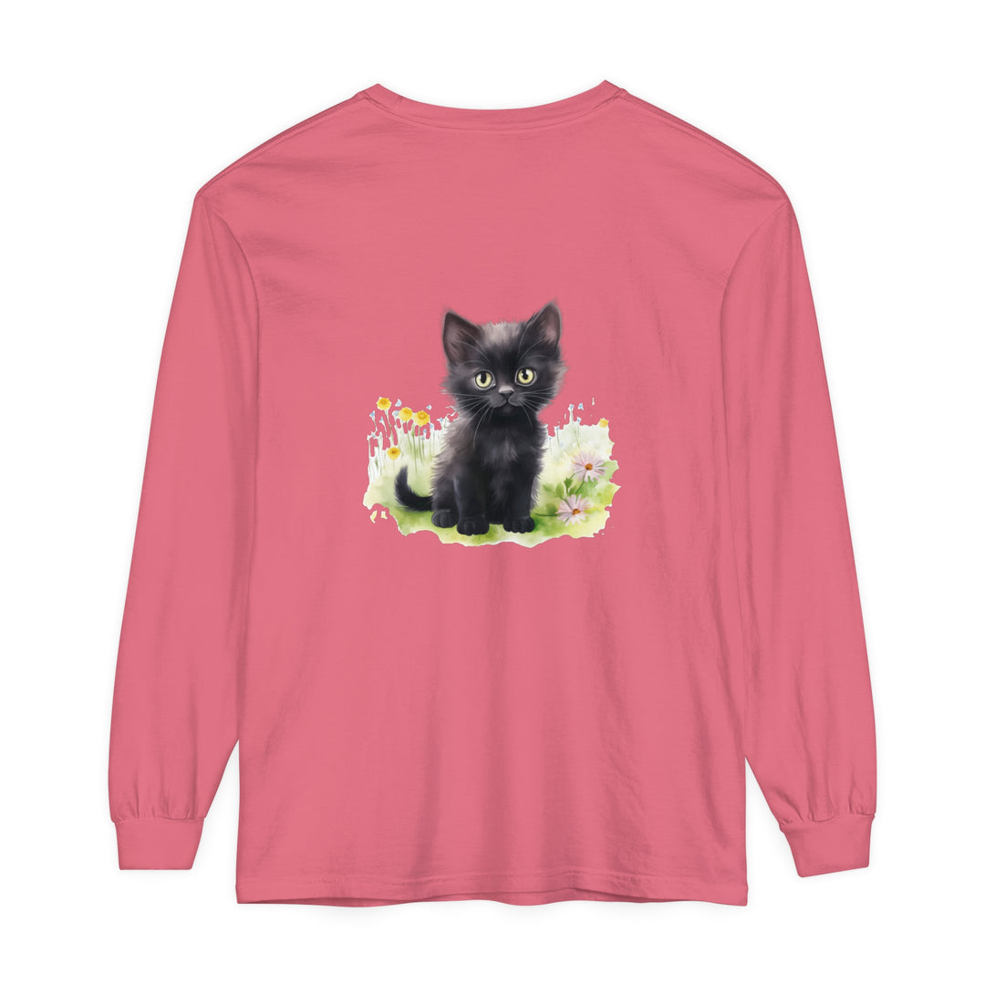 A cute black kitten plays in a colorful flower garden on a long sleeve t-shirt