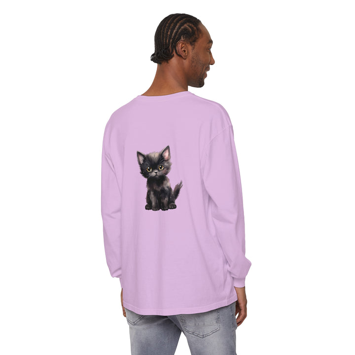 A black kitten with bright yellow eyes lounges on a long sleeve t-shirt