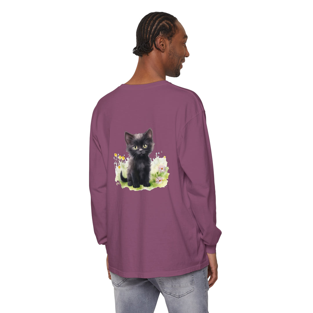 A cute black kitten sits among colorful flowers on a long sleeve t-shirt