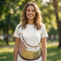 Cream-colored t-shirt with Cozy Crescent Cat boho line art; lifestyle studio flatlay showing the shirt's soft texture and warm palette, featuring a subtle cat design on light fabric.