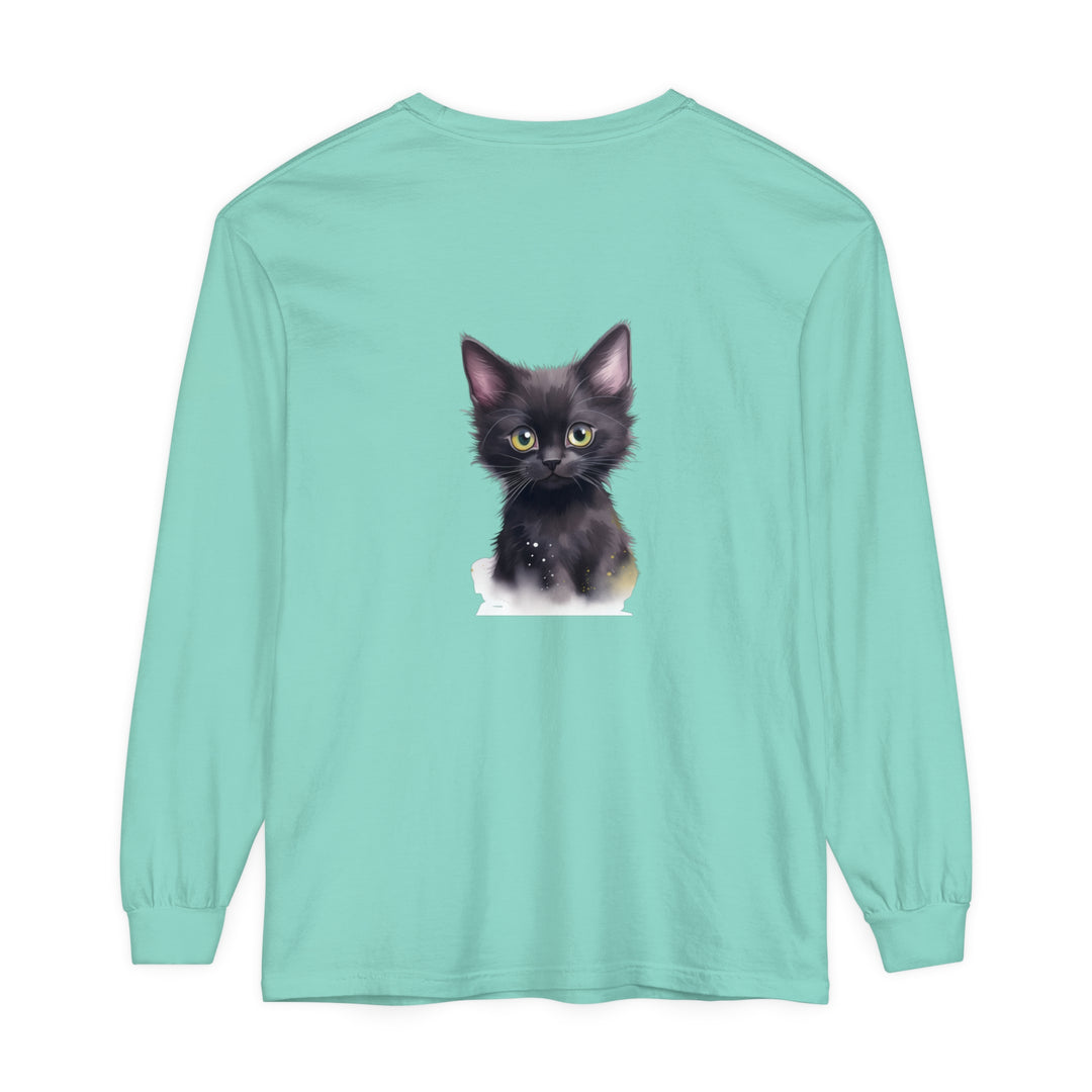 Cute black kitten with bright green eyes sitting on a white t-shirt