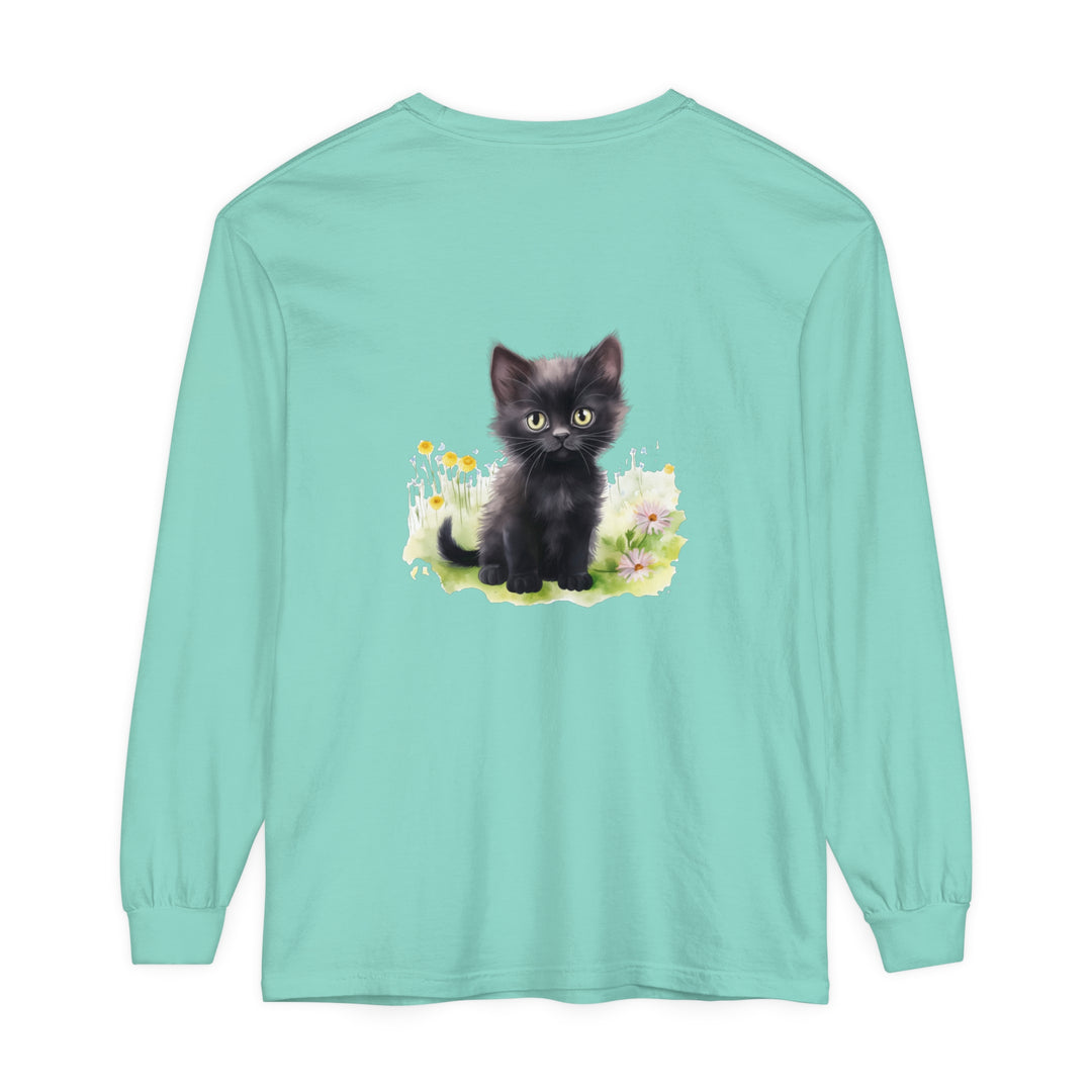 A cute black kitten exploring a colorful flower garden on a long sleeve t-shirt