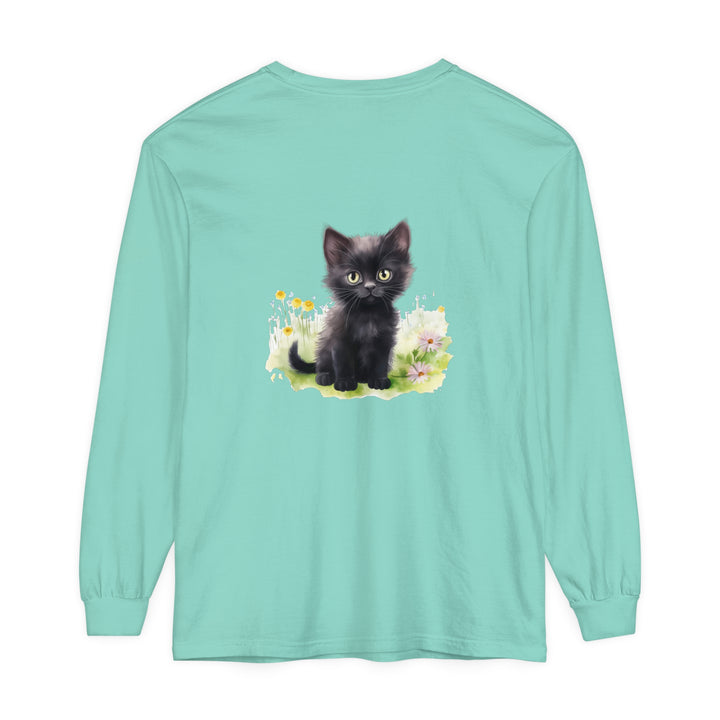 A cute black kitten exploring a colorful flower garden on a long sleeve t-shirt