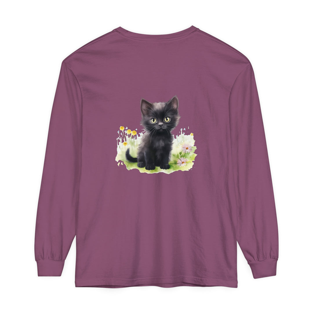 A cute black kitten exploring a colorful flower garden on a long sleeve t-shirt