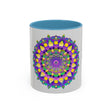 A hand-painted ceramic mug in purple and yellow featuring a mandala design