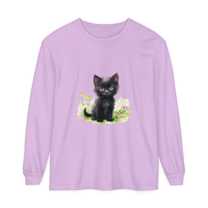 A playful black kitten sits among colorful flowers on a long sleeve t-shirt