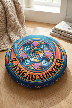 Close-up of a round tufted floor pillow featuring a blue-purple winter sacred-geometry cat with vibrant geometric rings; lifestyle setting for cozy, playful moments