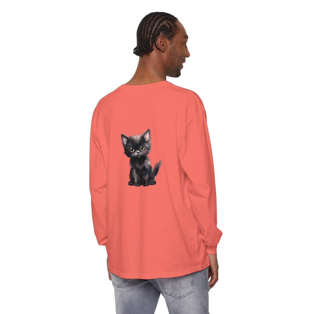 A black kitten with striking yellow eyes sitting on a long sleeve t-shirt