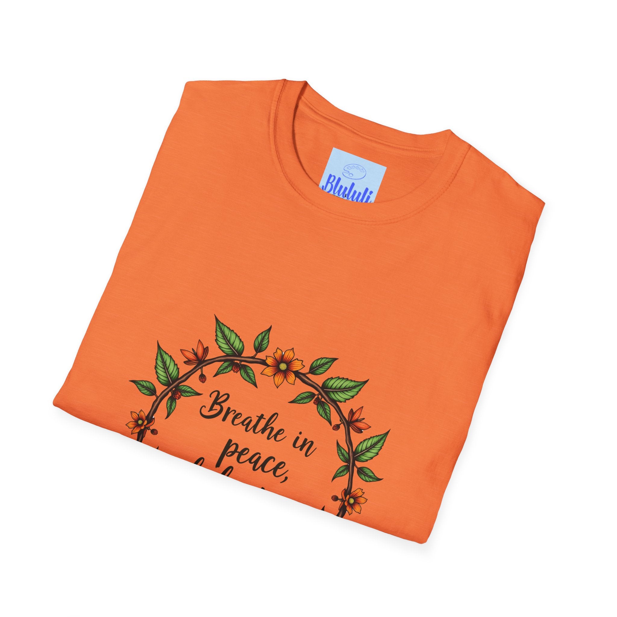 A soft, white t-shirt with a colorful floral garland design and the text Breathe in Peace, Exhale Stress in a relaxing, calming font