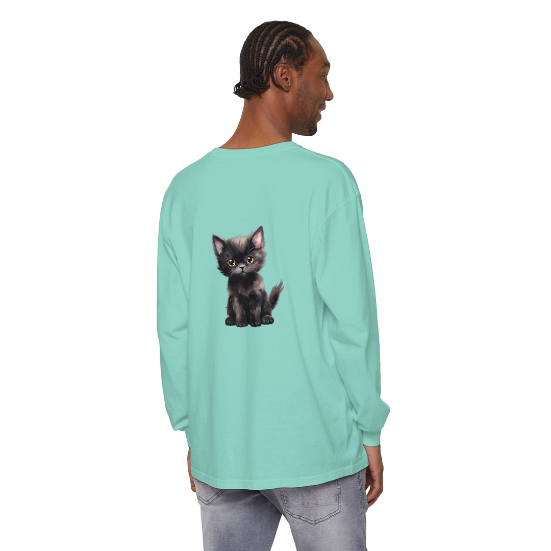 Adorable black kitten with striking yellow eyes lounging on a long sleeve t-shirt