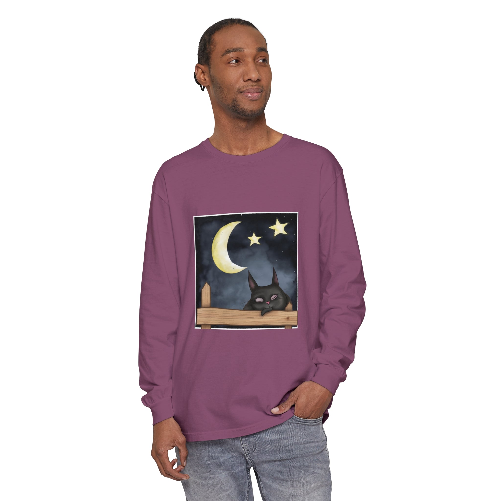 A close up image of a black t-shirt with a sleepy cat design against a night sky background