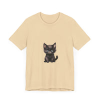 A fluffy white kitten with bright blue eyes sits on a pink T-shirt, looking adorable