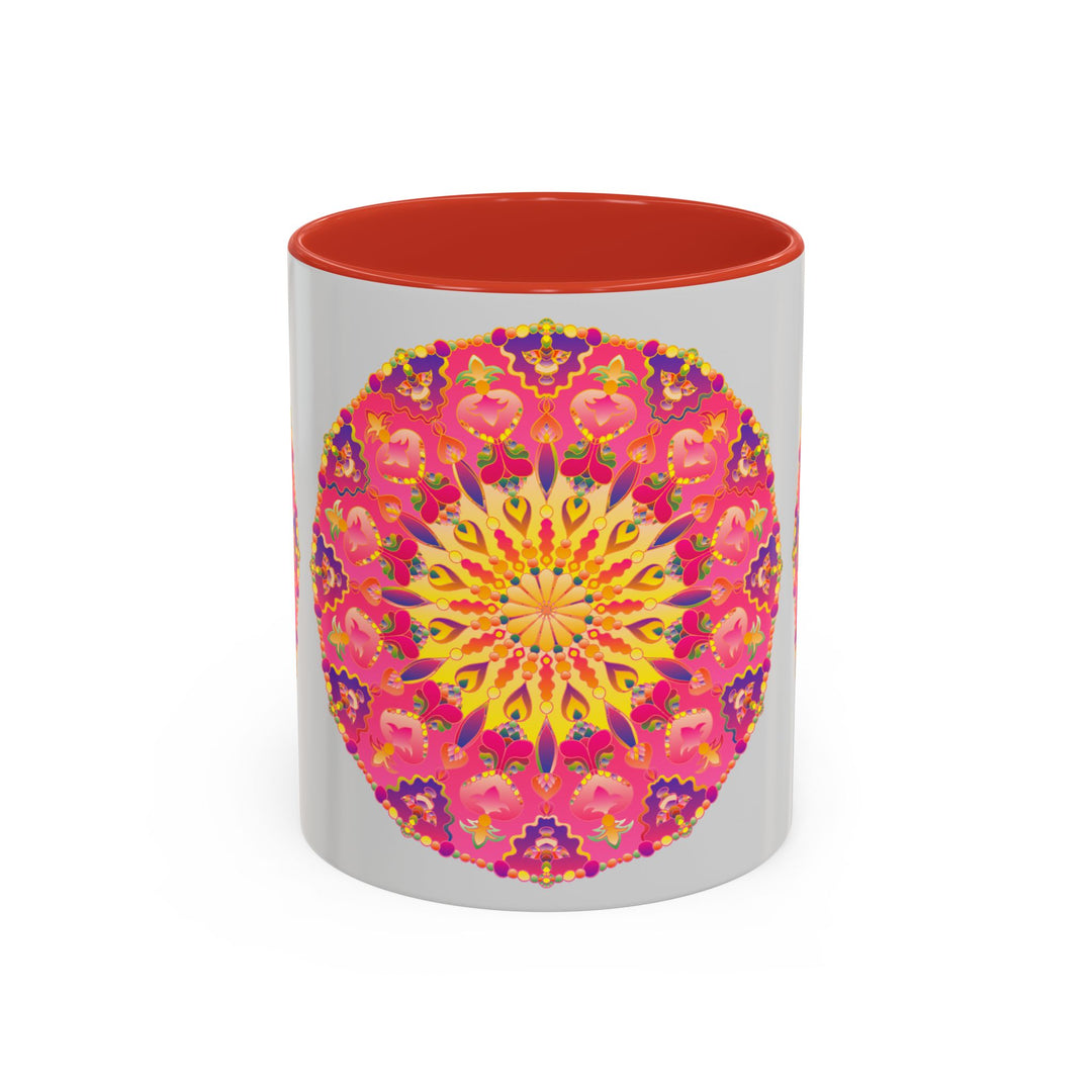 A close-up image of a ceramic mug with a mandala art design in pink, yellow, and green colors