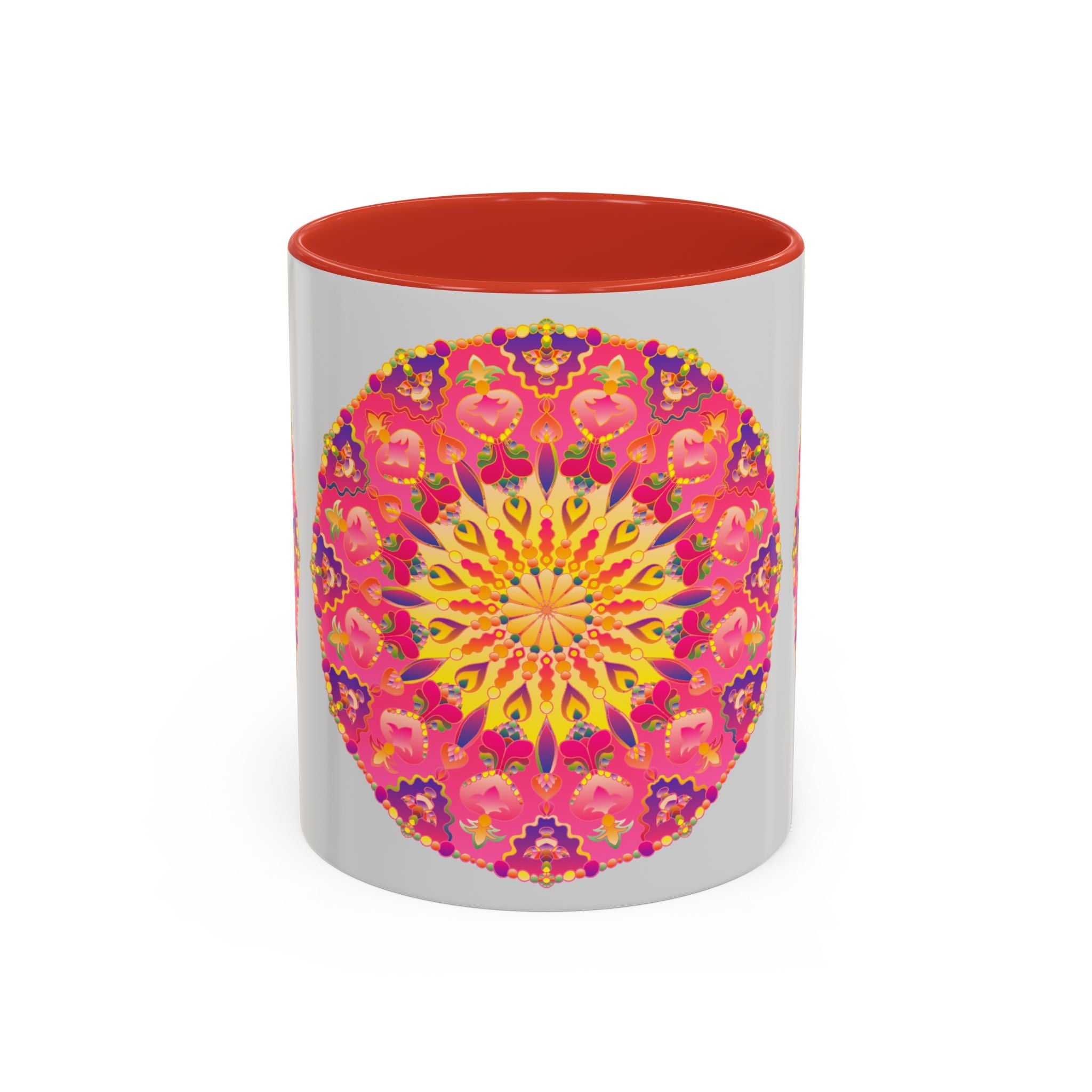 A close-up image of a ceramic mug with a mandala art design in pink, yellow, and green colors