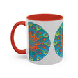 A close-up image of a ceramic mug featuring an intricate mandala art design in shades of blue and green