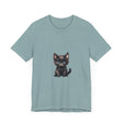 A fluffy white kitten with striking blue eyes wearing a cute t-shirt