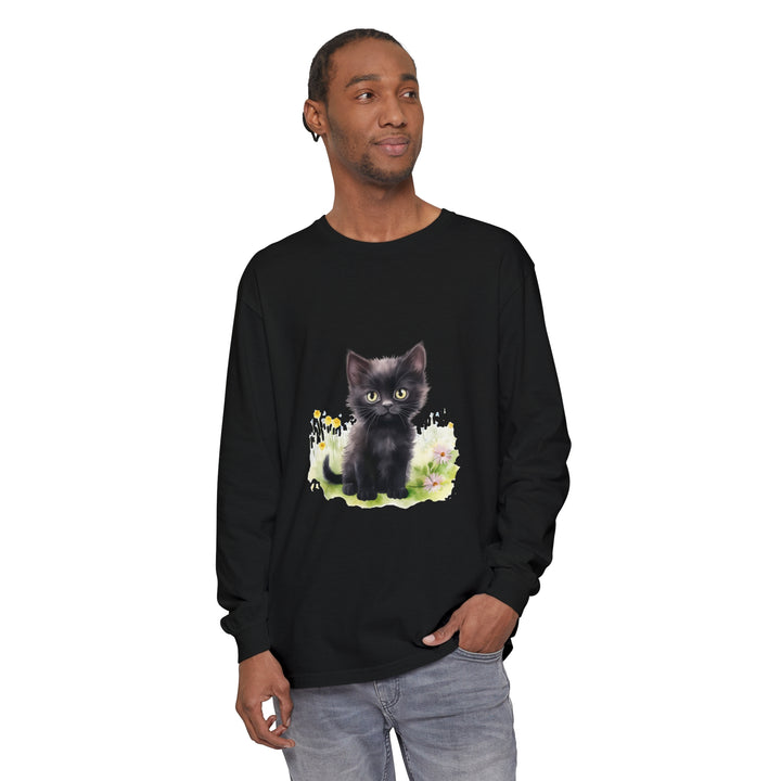 A cute black kitten exploring a vibrant flower garden on a long sleeve t-shirt