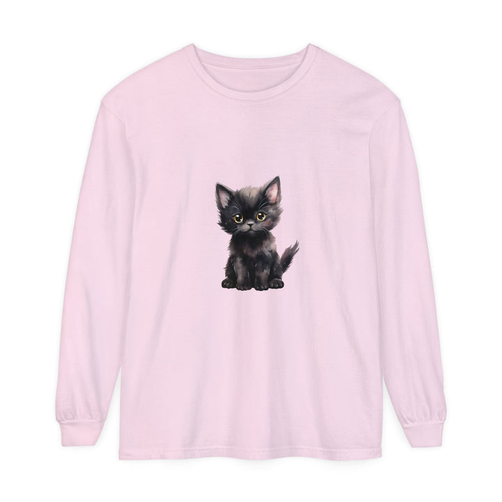 A cute black kitten with striking yellow eyes lounges on the front of a long sleeve t-shirt