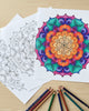 Colorful mandala drawing on paper with coloring pencils on a wooden surface