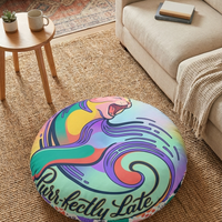 Teal round tufted cat floor pillow with surreal crescent-cat design; bold winter whimsy colors in a cozy living room lifestyle scene, close-up shot suitable for product and lifestyle use.