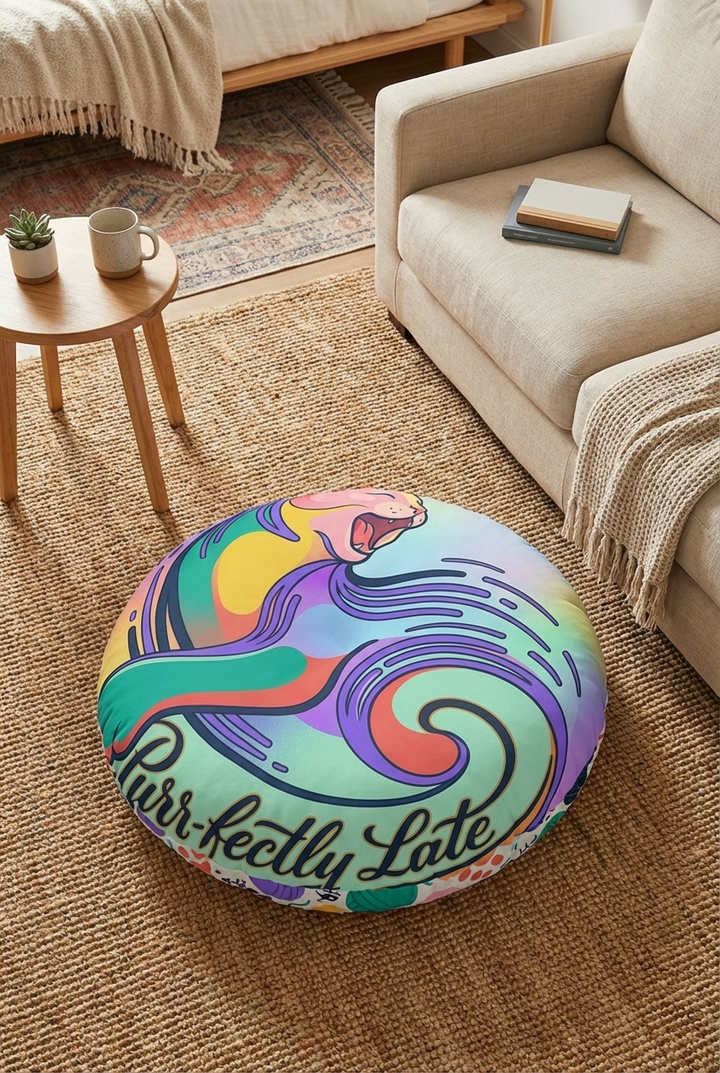 Teal round tufted cat floor pillow with surreal crescent-cat design; bold winter whimsy colors in a cozy living room lifestyle scene, close-up shot suitable for product and lifestyle use.