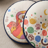 Close-up of a round Boho Cozy Cat Floor Pillow in warm winter crescent colors, featuring pink, yellow, mint, and blue tones; lifestyle close-up showing a cozy living room setting with the cat-themed pillow as a accent.