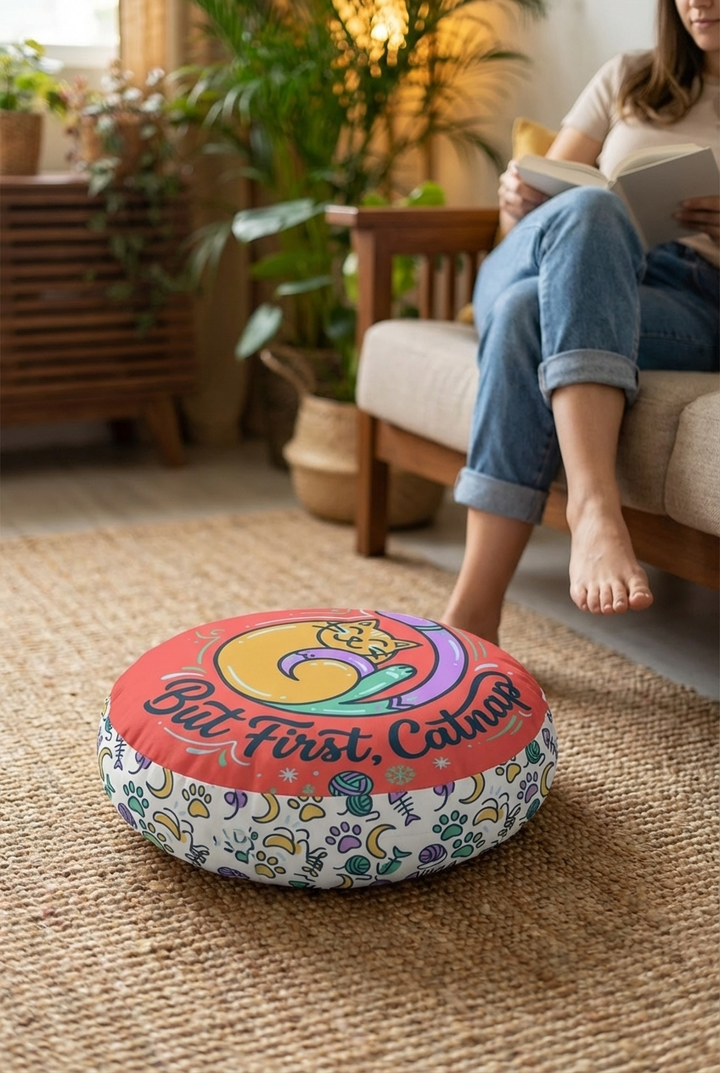 Round Cozy Curl Cat Floor Pillow featuring warm coral and mint tones, winter cat design, lifestyle close-up in a living room setting with soft textures. 