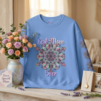 Blue sweatshirt with floral design and text on a wooden surface with decorative items.