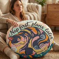 Winter cozy kitten in Ukiyo-e rhythm round floor pillow featuring teal and coral colors, lifestyle close-up in a reading nook with a cat-centered design and bold calligraphy, showing the pillow in use in a cozy living space.