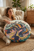 Winter cozy kitten in Ukiyo-e rhythm round floor pillow featuring teal and coral colors, lifestyle close-up in a reading nook with a cat-centered design and bold calligraphy, showing the pillow in use in a cozy living space.