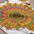 Lifestyle close-up of a colorful mandala art t-shirt with rainbow hues, highlighting soft fabric and detailed print, worn casually