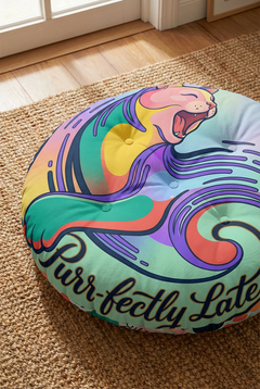 Close-up of a vibrant teal cat-themed round floor pillow with tufted texture and surreal crescent-cat motif; winter/post-New-Year whimsy vibe in a cozy living room setting, lifestyle shot showing a plush, comfortable ambiance.
