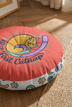 Close-up lifestyle shot of a Cozy Curl Cat Floor Pillow in warm coral (#FF6B6B) featuring a curled cat line-art design with mint, lilac, and navy accents; cozy winter cat theme in a living corner setting.