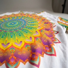 Lifestyle close-up of a colorful mandala design on a women's t-shirt, showing the print and soft knit fabric in vibrant detail
