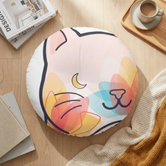 Round tufted cat floor pillow in pink tones with a cozy lifestyle setting; a curled cat silhouette on a double-exposure design, shown in a warm living room for a lifestyle context.