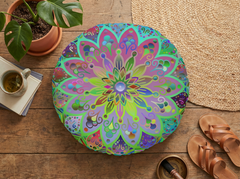 Lifestyle flatlay of a turquoise mandala floor cushion on a light surface, showcasing a hand-drawn, colorful round cushion with a double-sided print