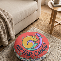 Round tufted floor pillow in warm coral (#FF6B6B) and mint surrounding a curled cat line-art design; lifestyle shot showing cozy winter interior with the cat-inspired cushion.